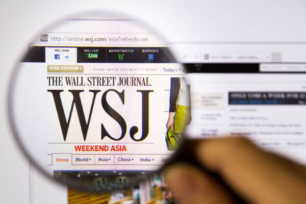 Bangkok Thailand APRIL 20 2014: Photo of The Wall Street Journal Monitor homepage on a monitor screen through a magnifying glass.